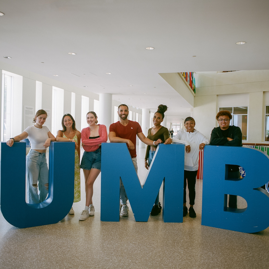 Students behind UMB sign