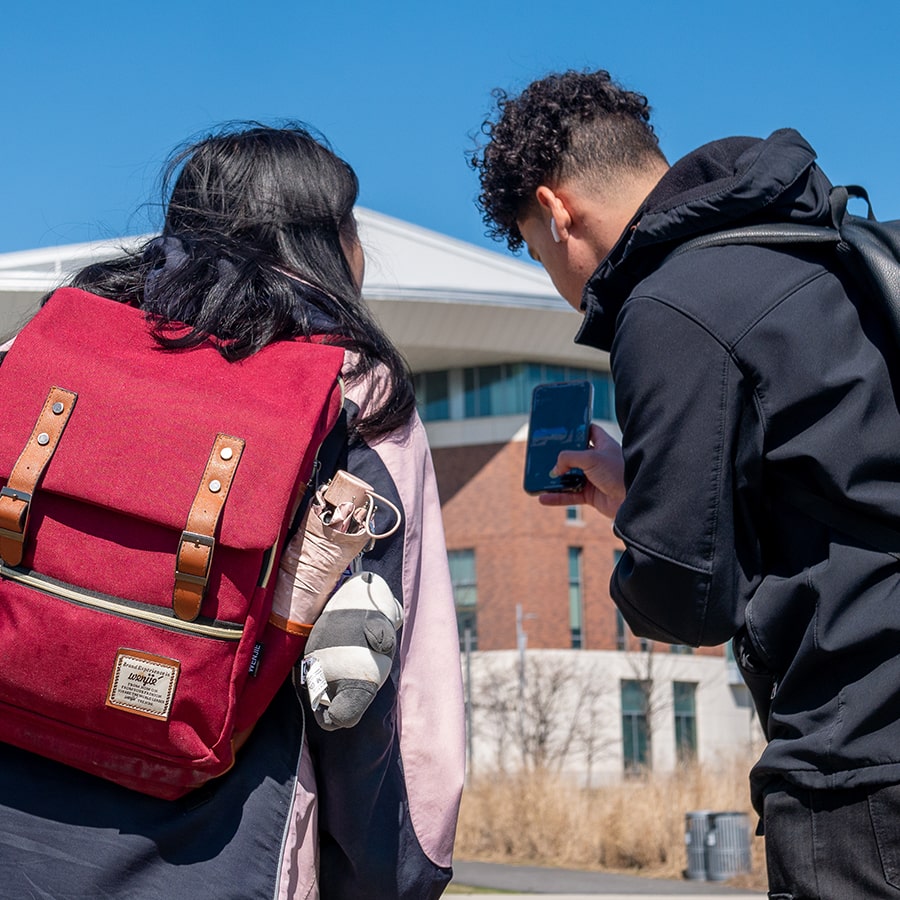 IT Students check cellphones outside Uhall photo by student Santiago Chaparro