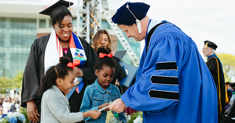 Rob Hale hands $1,000 to a graduate and her family.