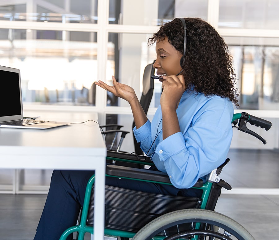 isabled woman talking with clients over the phone from her office using headset to offer assistance in customer service