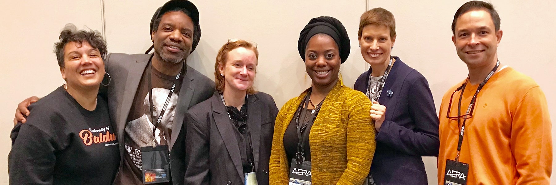 Urban Leadership in Education Phd students stand in a row indoors.