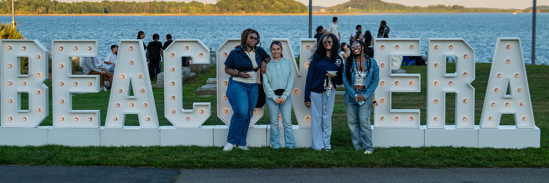 Students pose in front of Beacon Era sign on Campus Center Lawn.