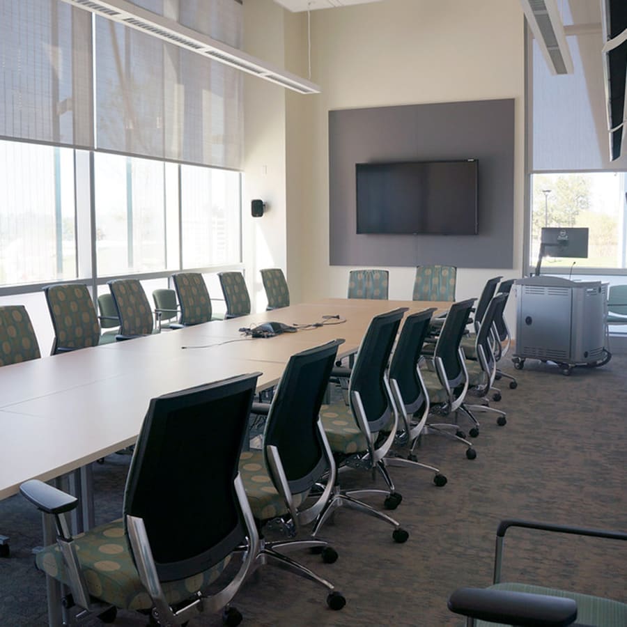Table and chairs set for a meeting in front of large window.