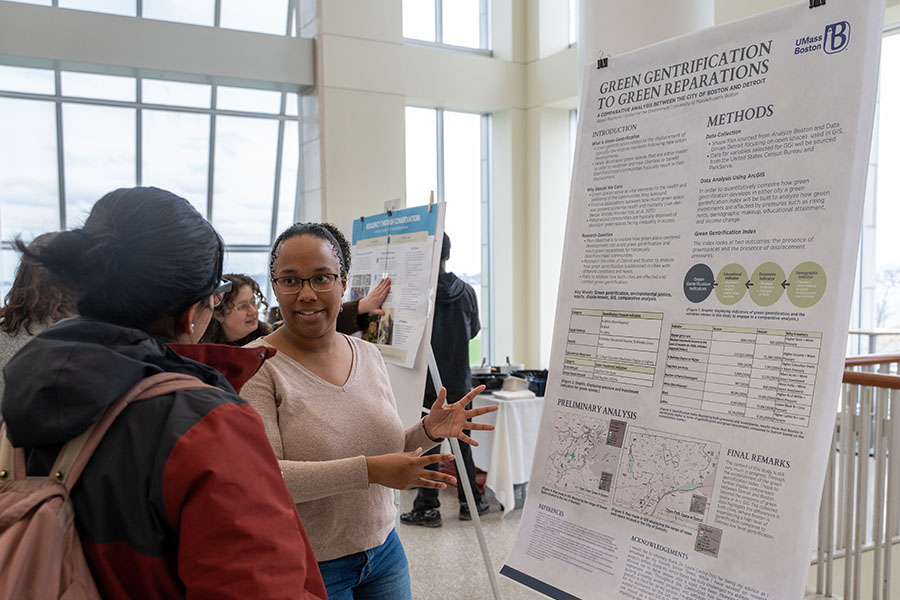 A student, Abigail Raymond, shows off her poster about Green Gentrification to Green Reparations at the 2026 Earth Day Symposium