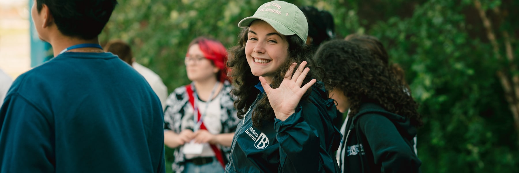 female student with cap looks back and waves